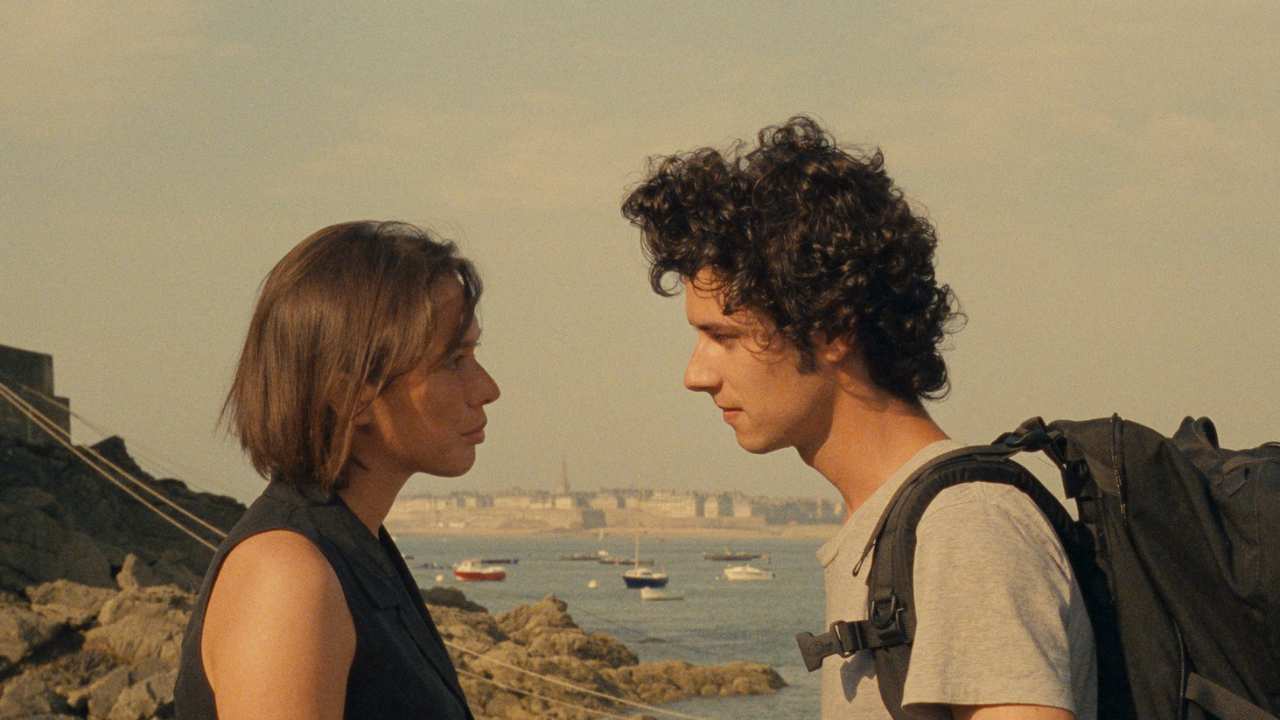 a woman and man standing on a beach
